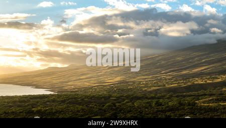 Gli ultimi raggi di un tramonto di Maui bagnano il paesaggio nella luce dorata lungo l'autostrada Piilani, accentuando la splendida topografia e il tranquillo oceano Foto Stock