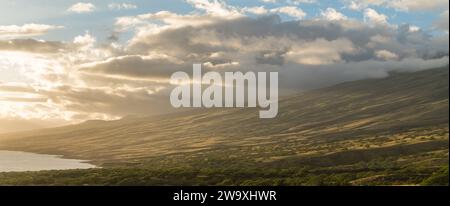 Gli ultimi raggi di un tramonto di Maui bagnano il paesaggio nella luce dorata lungo l'autostrada Piilani, accentuando la splendida topografia e il tranquillo oceano Foto Stock