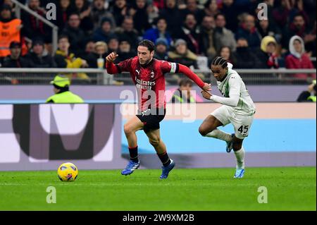 Milano. 30 dicembre 2023. Davide Calabria (L) dell'AC Milan sfida Armand Lauriente del Sassuolo durante la partita di calcio di serie A tra l'AC Milan e il Sassuolo a Milano, Italia, 30 dicembre 2023. Credito: Alberto Lingria/Xinhua/Alamy Live News Foto Stock