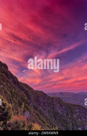 Nuvole rosse e rosa illuminate al tramonto sulla West Coast Range dal lago Tahune, dal parco nazionale Franklin-Gordon Wild Rivers, Tasmania, Australia Foto Stock