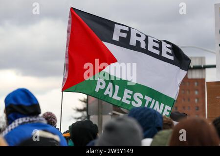 Harrisburg, Stati Uniti. 30 dicembre 2023. I manifestanti hanno una bandiera palestinese durante una manifestazione pro-palestinese. I manifestanti hanno piazzato più di 20.000 bandiere, una per ogni persona uccisa a Gaza dall'inizio della guerra Israele-Hamas, lungo la strada vicino alla residenza del governatore della Pennsylvania. Credito: SOPA Images Limited/Alamy Live News Foto Stock