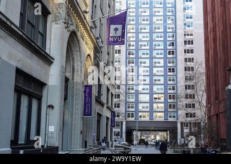 Una bandiera della New York University è appesa su un edificio del campus. La New York University (NYU) è una rinomata università privata di ricerca situata nel cuore di New York, conosciuta per il suo ambiente accademico diversificato e dinamico. Con una ricca storia che risale al 1831, la NYU è composta da più scuole, college e istituti, che offrono una vasta gamma di programmi di laurea, laurea e professionale in discipline come arti, scienze, affari, diritto e altro ancora. Il campus urbano e le iniziative di sensibilizzazione globale offrono agli studenti opportunità senza precedenti di imme culturale Foto Stock