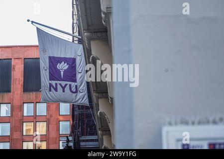 Una bandiera della New York University è appesa su un edificio del campus. La New York University (NYU) è una rinomata università privata di ricerca situata nel cuore di New York, conosciuta per il suo ambiente accademico diversificato e dinamico. Con una ricca storia che risale al 1831, la NYU è composta da più scuole, college e istituti, che offrono una vasta gamma di programmi di laurea, laurea e professionale in discipline come arti, scienze, affari, diritto e altro ancora. Il campus urbano e le iniziative di sensibilizzazione globale offrono agli studenti opportunità senza precedenti di imme culturale Foto Stock