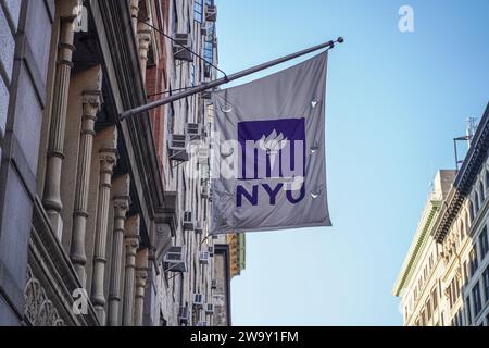 Una bandiera della New York University è appesa su un edificio del campus. La New York University (NYU) è una rinomata università privata di ricerca situata nel cuore di New York, conosciuta per il suo ambiente accademico diversificato e dinamico. Con una ricca storia che risale al 1831, la NYU è composta da più scuole, college e istituti, che offrono una vasta gamma di programmi di laurea, laurea e professionale in discipline come arti, scienze, affari, diritto e altro ancora. Il campus urbano e le iniziative di sensibilizzazione globale offrono agli studenti opportunità senza precedenti di imme culturale Foto Stock