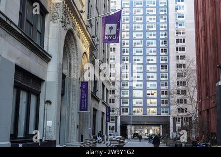 Una bandiera della New York University è appesa su un edificio del campus. La New York University (NYU) è una rinomata università privata di ricerca situata nel cuore di New York, conosciuta per il suo ambiente accademico diversificato e dinamico. Con una ricca storia che risale al 1831, la NYU è composta da più scuole, college e istituti, che offrono una vasta gamma di programmi di laurea, laurea e professionale in discipline come arti, scienze, affari, diritto e altro ancora. Il campus urbano e le iniziative di sensibilizzazione globale offrono agli studenti opportunità senza precedenti di imme culturale Foto Stock