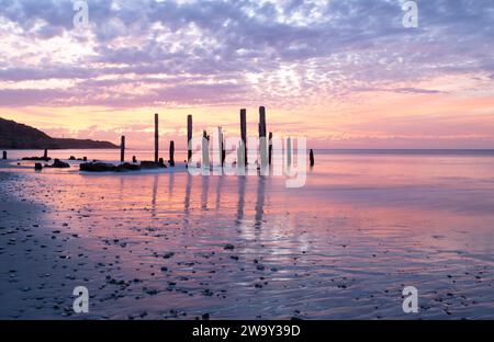 Port Willunga Beach jetty rovine in Australia del sud alight con gli inusuali colori pastello e porpora del tramonto. Foto Stock