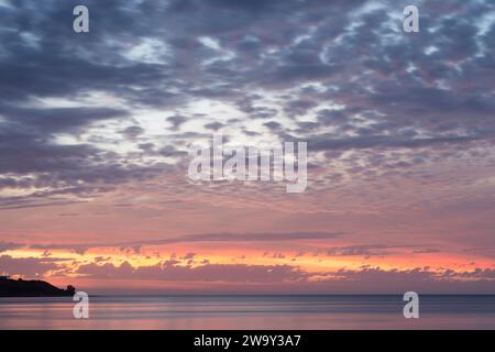 Incredibile, vivace e colorato tramonto nuvoloso sull'oceano, nell'Australia meridionale. Mostra solo una piccola quantità di terra. Foto Stock