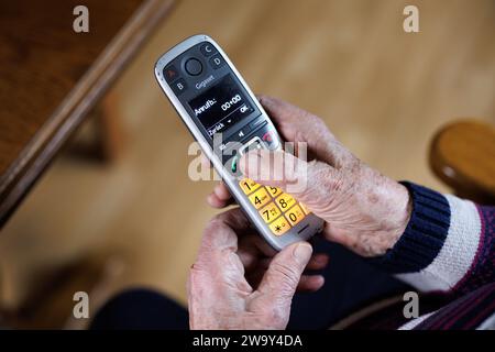 Norden, Germania. 28 dicembre 2023. Una signora anziana gestisce un telefono riservato agli anziani con pulsanti di selezione rapida. Crediti: Matthias Balk/dpa/Alamy Live News Foto Stock