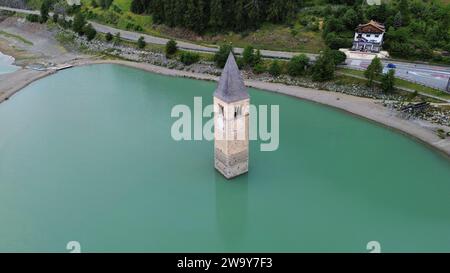 Vista aerea con drone del Lago di Resia (Reschensee con campanile sommerso a Curon Venosta, Alto Adige, Alpi italiane, Italia. Foto Stock