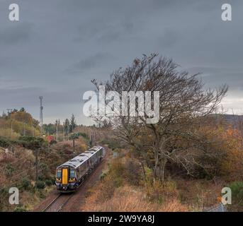 Treno elettrico ScotRail classe 380 che passa per la campagna dell'Ayrshire vicino a Hunterston sulla diramazione a binario singolo di Largs, Scozia, Regno Unito Foto Stock