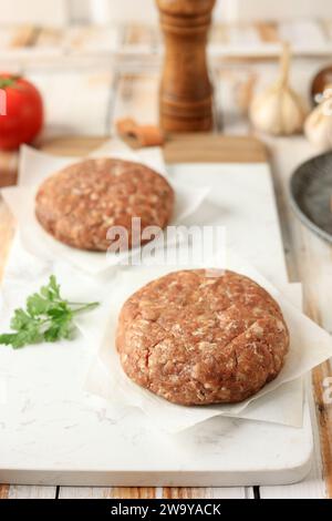 Raw Meat Burger Patty on Wooden Table, hamburger fatti in casa e polpettine di manzo Foto Stock