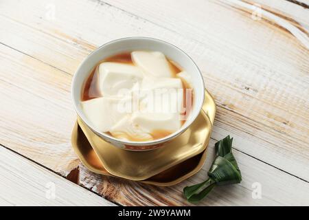 Kembang Tahu o Douhua o Tahua o giavanese lo chiama Wedang Tahu è budino di Tofu realizzato con latte di soia con zenzero e sciroppo di zucchero di palma. Foto Stock