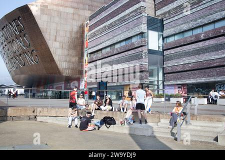 Giovani che chiacchierano al Roald Dahl Plass a Cardiff Bay, Cardiff, Regno Unito Foto Stock