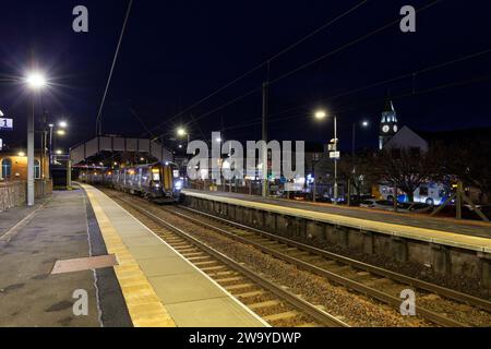 Treno elettrico ScotRail Siemens classe 380 380116 che effettua scalo notturno alla stazione ferroviaria di Saltcoates (Ayrshire), Scozia, Regno Unito. Foto Stock