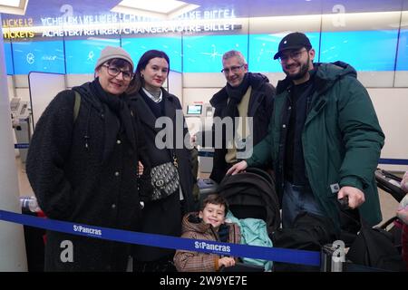 La famiglia Fenandez di Parigi (da sinistra a destra) Catherine Fernandez, 57 anni, sua figlia Luna Fernandez, 31 anni, marito Manuel Fernandez, 59 anni, figlio Emilio Fernandez, 22 anni, con Amani Fernandez di quattro anni, in attesa in coda per prenotare i biglietti per l'Eurostar nella stazione internazionale di St Pancras, nel centro di Londra. Eurostar ha annunciato che tutti i suoi servizi riprenderanno la domenica dopo che le inondazioni nei tunnel sotto il Tamigi sono state poste sotto controllo, anche se le restrizioni di velocità possono portare a ritardi. Data immagine: Domenica 31 dicembre 2023. Foto Stock