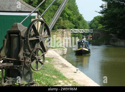 Canal Boat si avvicina a una gru nel bacino Brass Knocker all'incrocio tra il canale Kennet e Avon e il canale del carbone Somersetshire alla fine del Du Foto Stock