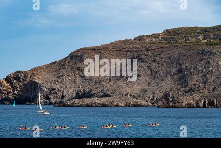 Un gruppo di persone in kayak pagaiano intorno alla baia di Fornells Menorca in Spagna Foto Stock