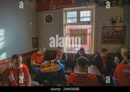 I tifosi di Liverpool bevono birra al pub Foto Stock