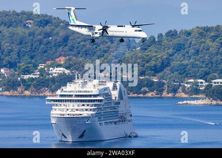 Skiathos, Grecia - 24 agosto 2023: Avanti air Dash 8 con una barca sullo sfondo che si avvicina all'aeroporto di Skiathos Foto Stock