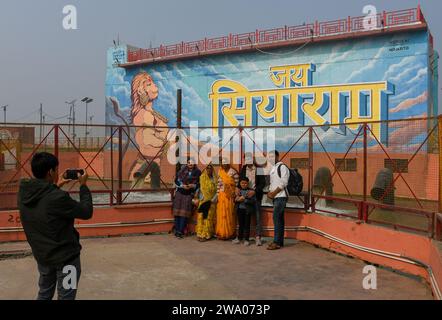 Ayodhya, India. 27 dicembre 2023. Le persone scattano foto di fronte a un murale del dio indù Hanuman ad Ayodhya. Ayodhya è un'antica città dell'India settentrionale che ha un grande significato religioso e storico nell'induismo, in quanto è considerata il luogo di nascita di Lord Rama, una divinità venerata nella mitologia indù. Nel novembre 2019, la Corte Suprema dell'India ha emesso una sentenza storica a favore della costruzione di un tempio indù nel controverso sito sito di Ayodhya. (Foto di Biplov Bhuyan/SOPA Images/Sipa USA) credito: SIPA USA/Alamy Live News Foto Stock