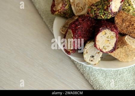 Molti panini di delizia turca con diversi sapori e ripieni in un piatto bianco sul tavolo. Tagli di dolci Turk Lokumu Foto Stock