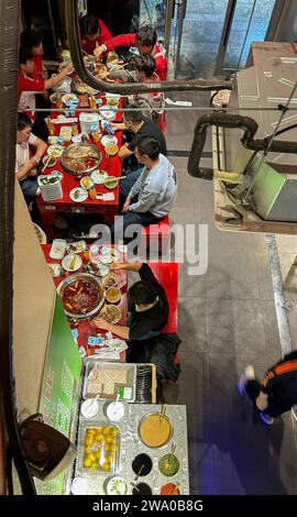 Pechino, Cina, vista ad angolo elevato, interno, media folla di persone, pasti, ristorante cinese, tavolo, Hot Pot, "Tan Ya Xue Old Hotpot", a tavola Foto Stock