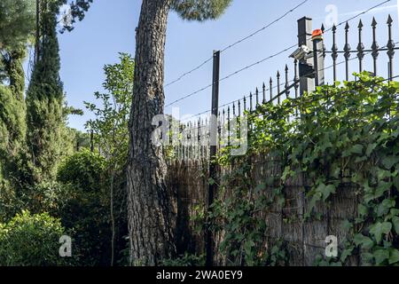 Una doppia recinzione di sicurezza con telecamere di sorveglianza e concertina sul perimetro di una fattoria Foto Stock