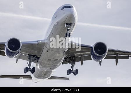 Immagine frontale e fusoliera di un grande velivolo commerciale con il carrello di atterraggio schierato, che prende quota subito dopo il decollo Foto Stock