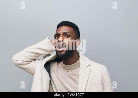 Felice giovane afro-americano gen z Guy isolato su sfondo beige. Sorridente hipster etnico teen studente, fresco riccio etnico generazione z adolescente Foto Stock