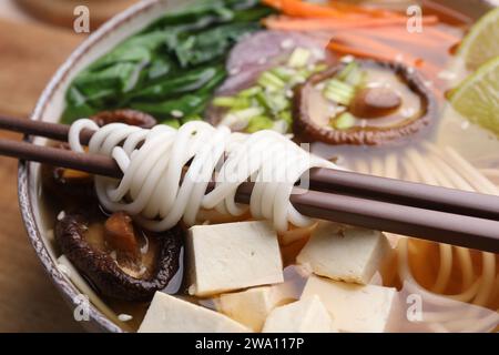 Ciotola di ramen vegetariano e bacchette sul tavolo, primo piano Foto Stock