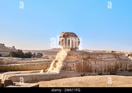 Giza, Egitto - 24 dicembre 2023: L'iconica scultura della Sfinge adiacente alle grandi Piramidi Foto Stock