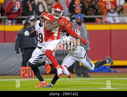 Kansas City, Stati Uniti. 31 dicembre 2023. Il wide receiver dei Kansas City Chiefs Rashee Rice (4) combatte per yard extra contro la safety dei Cincinnati Bengals Dax Hill (23) e il cornerback dei Bengals Cam Taylor-Britt (29) all'Arrowhead Stadium di Kansas City, Missouri, domenica 31 dicembre 2023. I Chiefs sconfissero i Bengals 25-17. Foto di Jon Robichaud/UPI credito: UPI/Alamy Live News Foto Stock