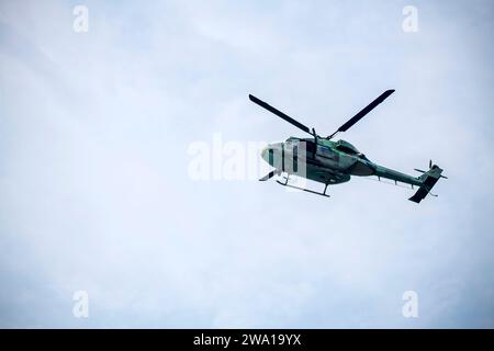 L'elicottero militare sta volando su un cielo blu isolato. Foto Stock