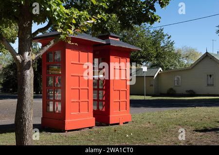 Due vecchie cabine telefoniche rosse affiancate sul prato lungo una strada a Ross, Tasmania Foto Stock