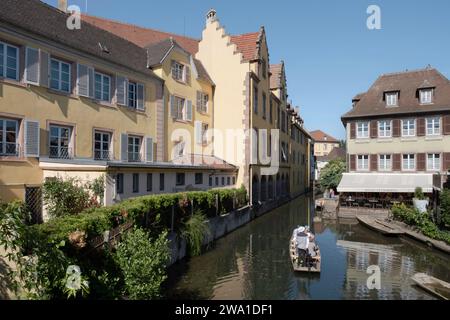 Splendida vista sulla storica città di Colmar, conosciuta anche come la piccola Venezia, con i turisti che fanno una gita in barca passando davanti alle tradizionali case colorate Foto Stock