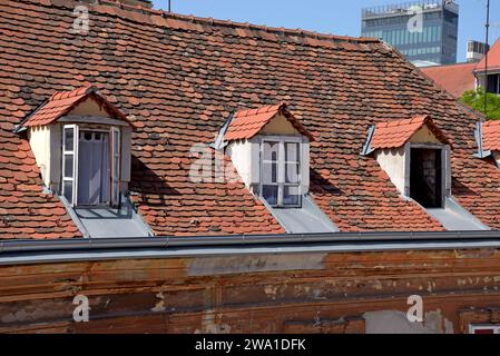 Un tetto basso con piastrelle rosse e finestre dormitori nella zona della città vecchia di Zagabria, Croazia Foto Stock