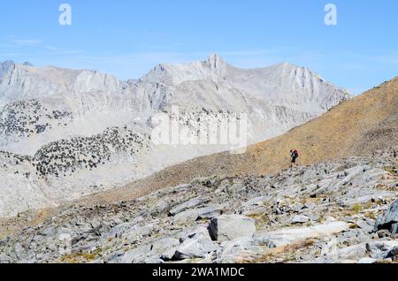 Un escursionista con zaino in spalla va dal White Pass al Red Pass sulla Sierra High Route nel Kings Canyon National Park, CALIFORNIA. Foto Stock