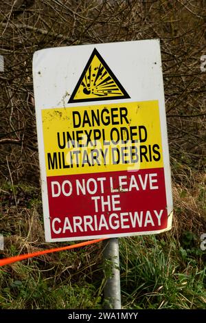 Il "villaggio perduto" di Imber, Salisbury Plain, Wiltshire, Regno Unito, mostra la chiesa, Imber Court (persiane verdi), le case di addestramento dell'esercito e un cartello di avvertimento. Foto Stock