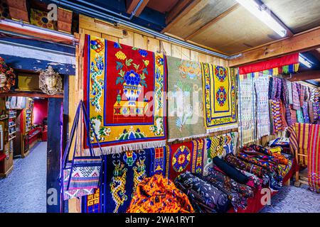 Tappeti tradizionali, tappeti, tessuti e souvenir in vendita nel Thokmed Yeshey Handicraft & Yathra Production Center, Chumey, Bumthang, Bhutan Foto Stock