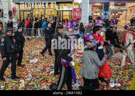 New York, Stati Uniti. 1 gennaio 2024. Gli agenti di polizia richiedono che la gente lasci Times Square. Dopo la tradizionale celebrazione del conto alla rovescia e l'iconica caduta della palla a Times Square, le conseguenze rivelano una scena cosparsa di resti di coriandoli e detriti scartati. Subito dopo la rivelazione, il Dipartimento di Sanitazione della città di New York (DSNY) mobilita un team dedicato di operai per la pulizia per affrontare rapidamente il gigantesco compito di riportare Times Square al suo stato incontaminato. Credito: SOPA Images Limited/Alamy Live News Foto Stock