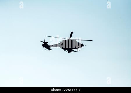 Silhouette Helicopter che vola su un cielo blu isolato Foto Stock