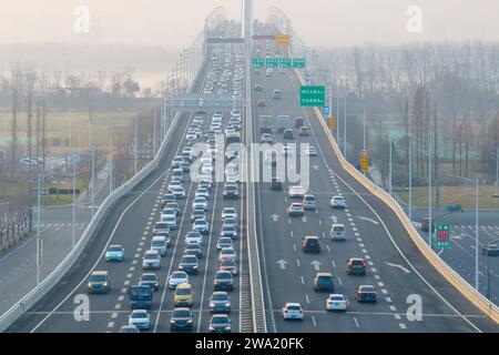 Nanjing. 1 gennaio 2024. Questa foto aerea scattata il 1° gennaio 2024 mostra veicoli che corrono sul ponte del fiume Jiangxinzhou Yangtze a Nanchino, nella provincia di Jiangsu della Cina orientale. Lunedì è l'ultimo giorno della festa di tre giorni di Capodanno 2024 in Cina. Crediti: Fang Dongxu/Xinhua/Alamy Live News Foto Stock