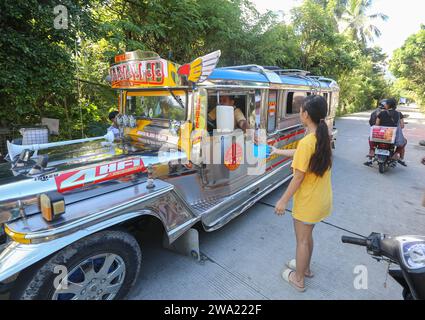 Tiaong, Filippine. 1 gennaio 2024: Nelle province rurali, le famiglie povere filippine costruiscono strade a pedaggio amichevoli con una corda e un cartello di felice anno nuovo. Auto, tricicli o pedoni sono incoraggiati a fare donazioni "grazie", generalmente solo pochi pesos, senza impegno, sempre con sorriso e talvolta abbelliti da pochi passi di danza. Una tradizione che era praticata solo in alcune regioni e che si è diffusa in quasi tutto il paese dai giorni duri dell'epidemia di COVID 19. Ad esempio, oltre 1 km, in alcuni luoghi è possibile contare fino a quindici fermate. Crediti: Kevin Izorce/Alamy Live News Foto Stock