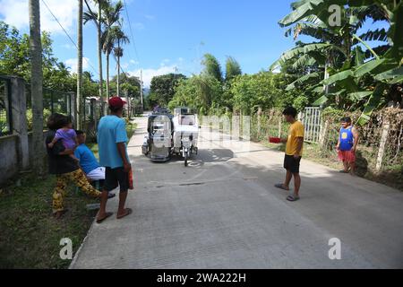 Tiaong, Filippine. 1 gennaio 2024: Nelle province rurali, le famiglie povere filippine costruiscono strade a pedaggio amichevoli con una corda e un cartello di felice anno nuovo. Auto, tricicli o pedoni sono incoraggiati a fare donazioni "grazie", generalmente solo pochi pesos, senza impegno, sempre con sorriso e talvolta abbelliti da pochi passi di danza. Una tradizione che era praticata solo in alcune regioni e che si è diffusa in quasi tutto il paese dai giorni duri dell'epidemia di COVID 19. Ad esempio, oltre 1 km, in alcuni luoghi è possibile contare fino a quindici fermate. Crediti: Kevin Izorce/Alamy Live News Foto Stock