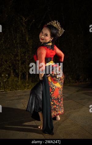 Una ballerina vietnamita che indossa un costume rosso e gioielli d'oro sul palco di notte Foto Stock