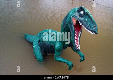 Stourport-on-Severn, Worcestershire, 1 gennaio 2024 - Dennis il dinosauro ha le ginocchia bagnate. - Il livello dell'acqua è salito attraverso Stourport-on-Severn lunedì, quando Storm Henk ha portato gravi avvertimenti di inondazione in gran parte del Regno Unito. Un modello di dinosauro in un campo da minigolf, chiamato Dennis dalla gente del posto che lo usa come misuratore dell'altezza delle inondazioni, è ora Geoffrey la Giraffa è anche "altezza delle spalle" nelle vicinanze. Un modello Zebra e Tiger potevano anche essere visti parzialmente sommersi. La fiera di Treasure Island è ora più isola come prima. Credito: Stop Press Media/Alamy Live News Foto Stock