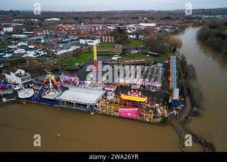 Stourport-on-Severn, Worcestershire, 1 gennaio 2024 - il livello dell'acqua è salito attraverso Stourport-on-Severn lunedì, mentre Storm Henk ha portato gravi avvertimenti di inondazione in gran parte del Regno Unito. Un modello di dinosauro in un campo da minigolf, chiamato Dennis dalla gente del posto che lo usa come misuratore dell'altezza delle inondazioni, è ora Geoffrey la Giraffa è anche "altezza delle spalle" nelle vicinanze. Un modello Zebra e Tiger potevano anche essere visti parzialmente sommersi. La fiera di Treasure Island è ora più isola come prima. Credito: Stop Press Media/Alamy Live News Foto Stock