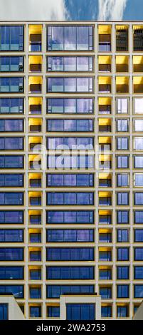 Cielo blu riflesso, finiture in bronzo giallo e calcestruzzo bianco scuro creano motivi impressionanti al 551 West 21st Street, un condominio residenziale. Foto Stock