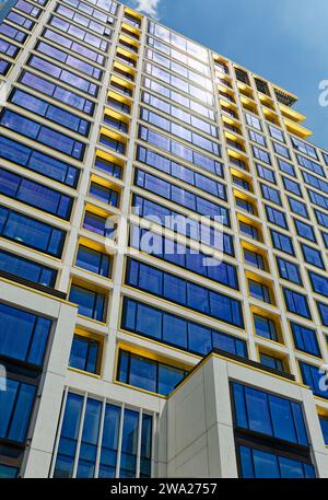 Cielo blu riflesso, finiture in bronzo giallo e calcestruzzo bianco scuro creano motivi impressionanti al 551 West 21st Street, un condominio residenziale. Foto Stock