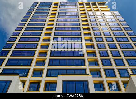 Cielo blu riflesso, finiture in bronzo giallo e calcestruzzo bianco scuro creano motivi impressionanti al 551 West 21st Street, un condominio residenziale. Foto Stock